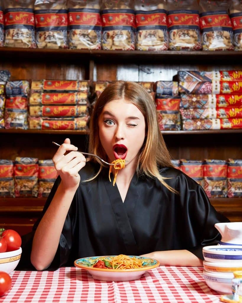 Girl eating pasta and winking her eye